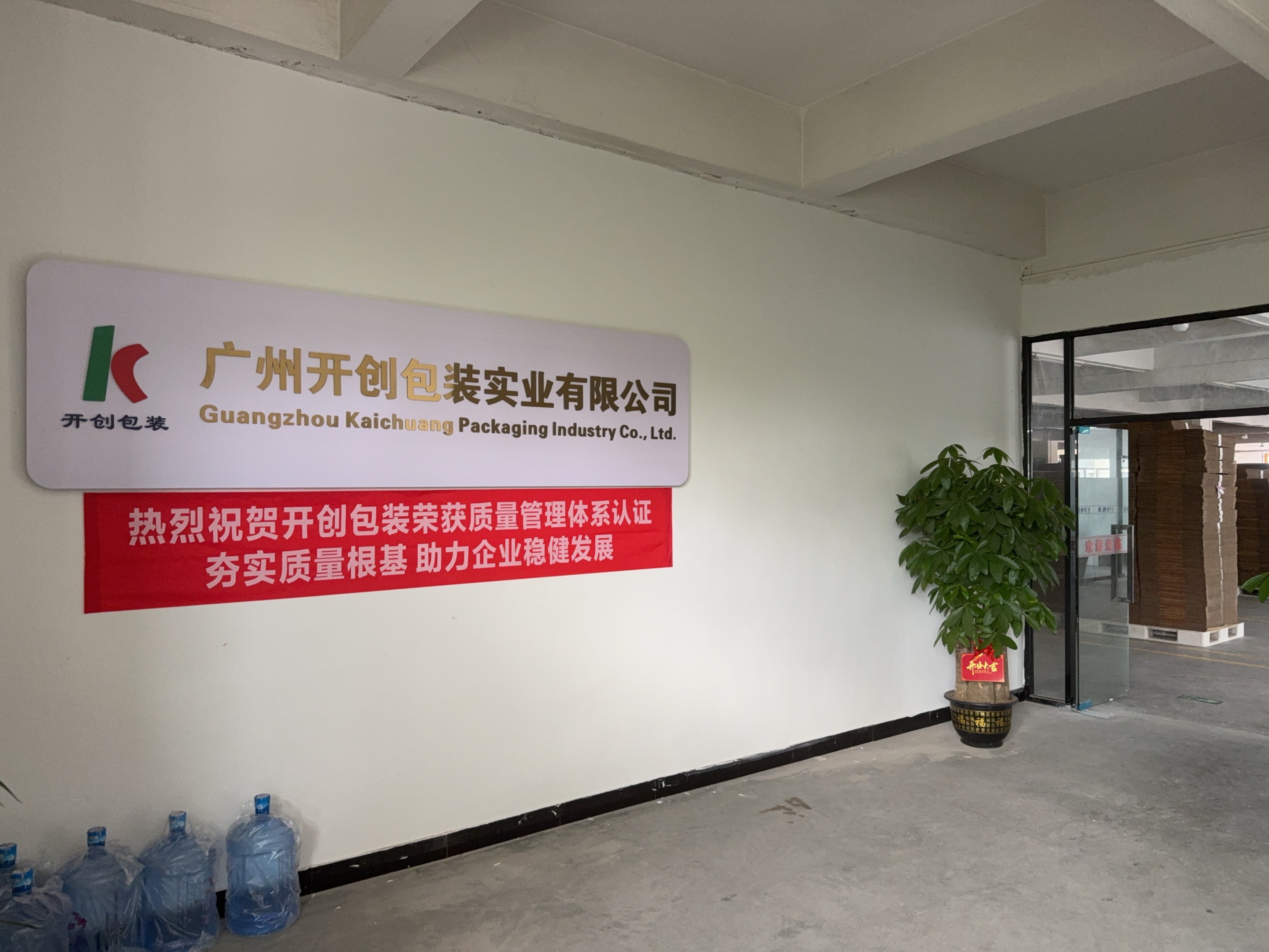 开创包装办公室原始实拍：企业标识下的质量管理体系认证横幅